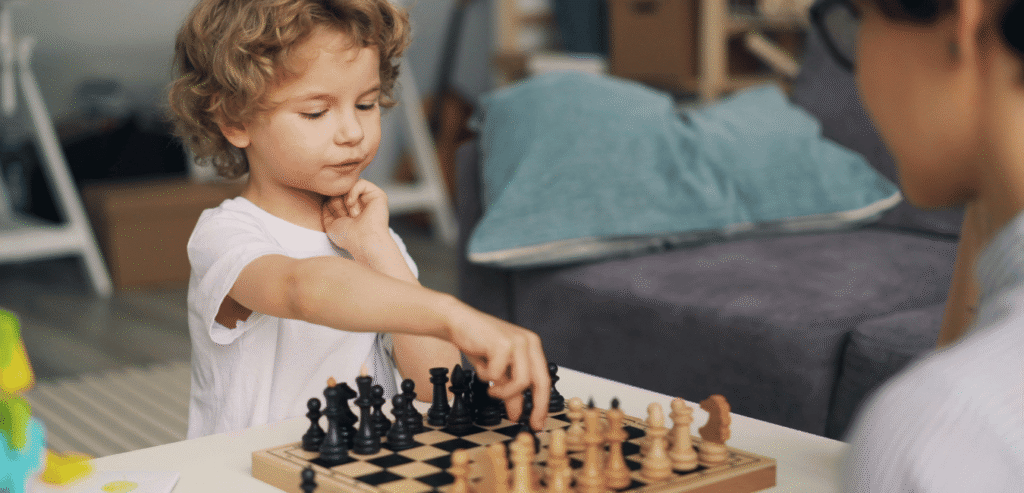 A girl playing chess, concentrating on the board.