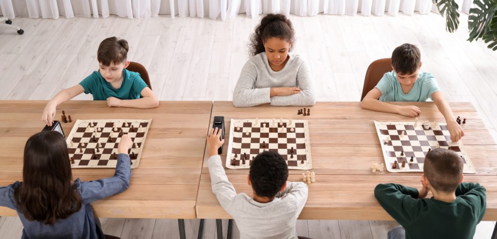 Children playing chess in a classroom setting, highlighting engagement and concentration.